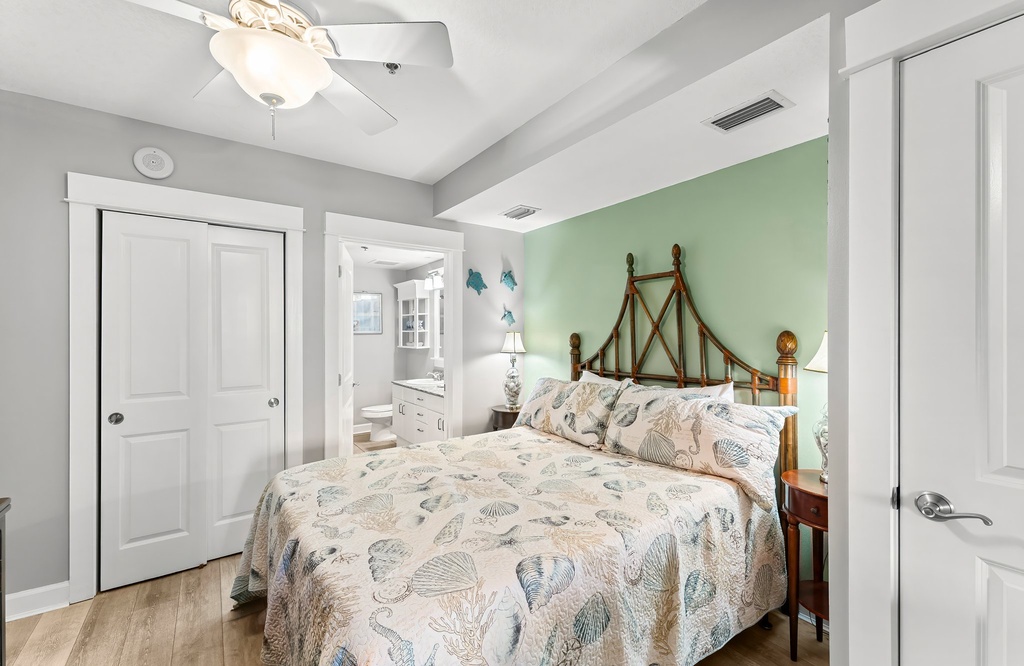 Cozy bedroom with a decorative wooden headboard and soft sea-themed bedding.