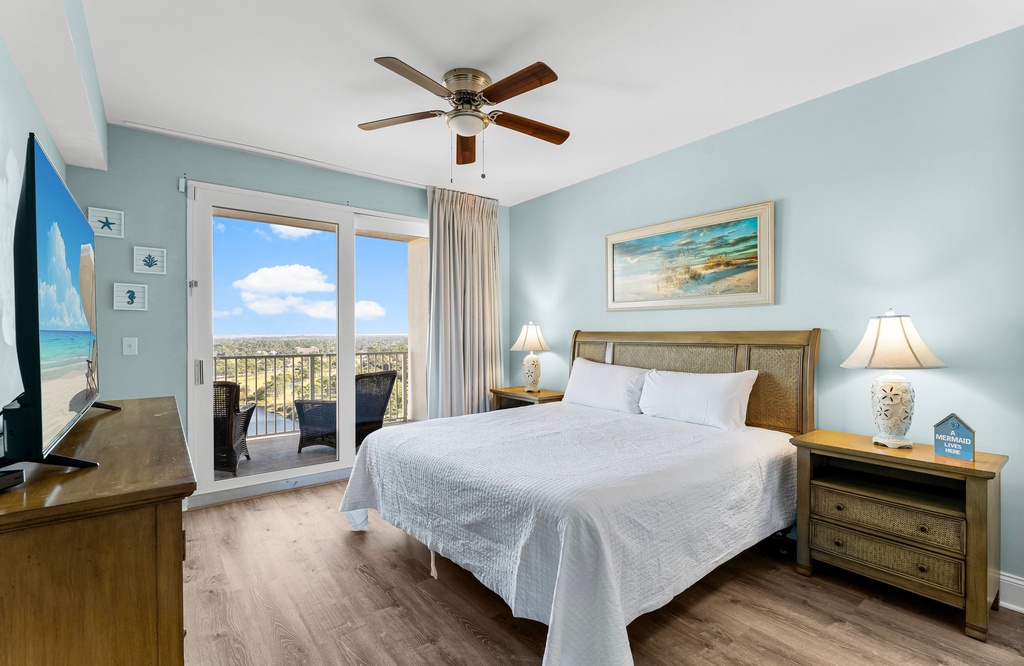 Relax in this coastal-inspired bedroom with balcony views.