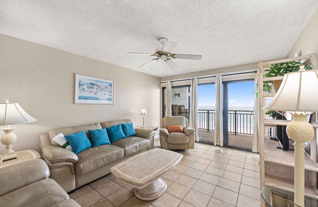 Relax in your beachfront living room where comfortable leather seating and ocean breezes through sliding doors create the perfect coastal retreat.