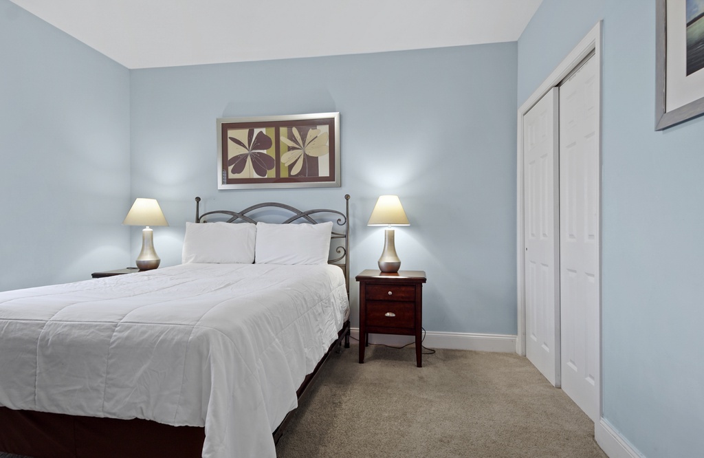 Cozy bedroom with soft blue walls and warm bedside lighting