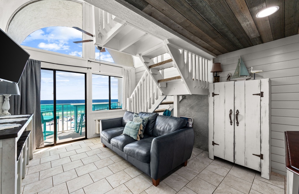 Coastal retreat with floor-to-ceiling glass doors framing turquoise waves. Rustic wood ceilings and whitewashed walls create beachy-chic charm, while the private balcony offers the perfect ocean-view morning coffee spot.