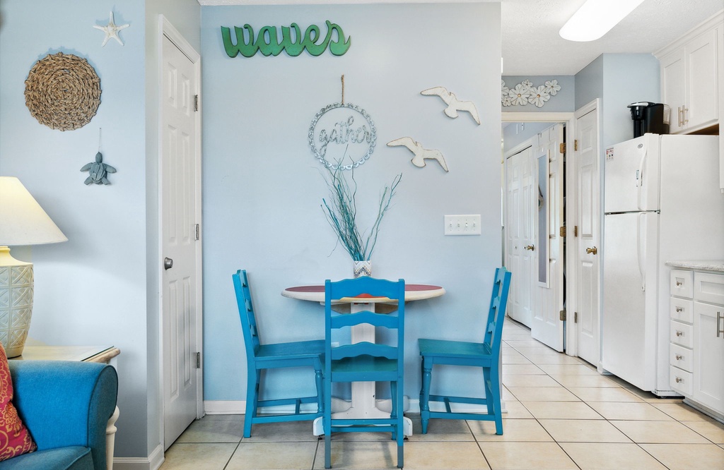 Cozy dining nook with blue chairs and coastal decor for a relaxing meal.