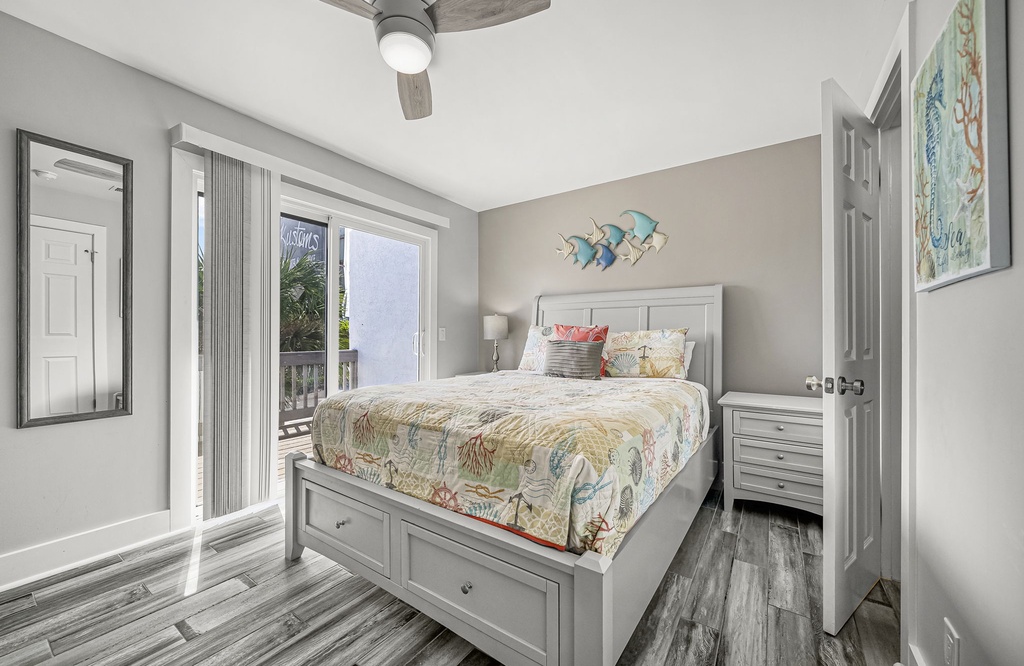 Cozy bedroom with a queen bed and sliding door to a balcony.