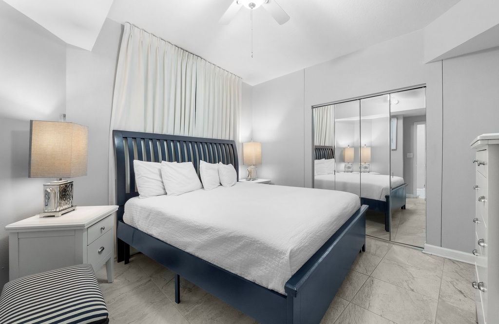 Spacious primary bedroom w/ a bold navy bed frame & plenty of natural light.