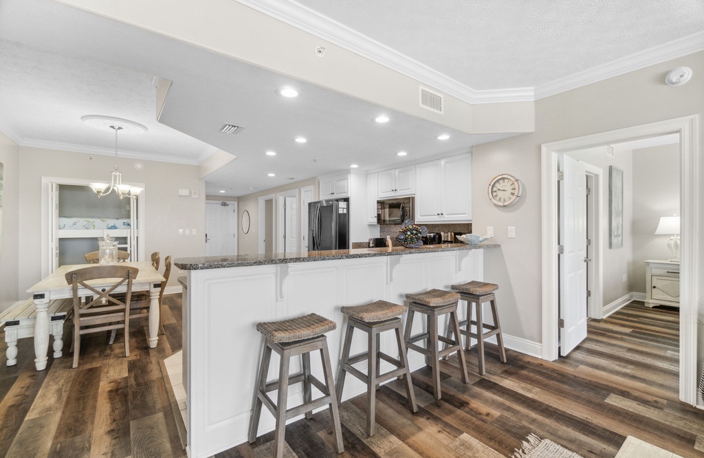 Sleek kitchen w/ white cabinetry, bold island & bar seating — ready for easy meal prep.