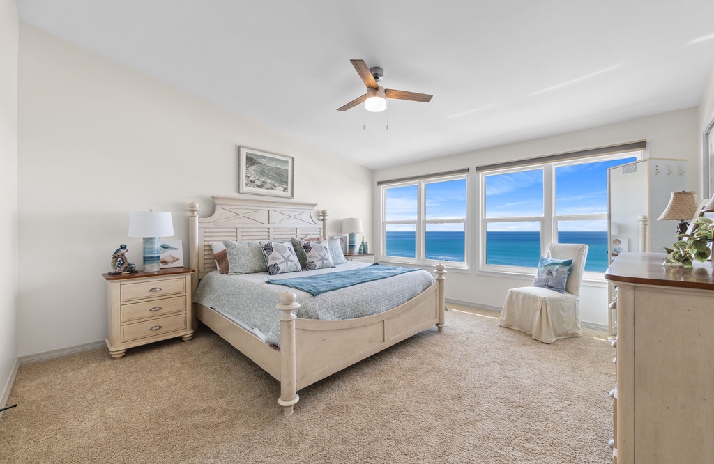 Relax in this bright bedroom with ocean views and coastal decor.