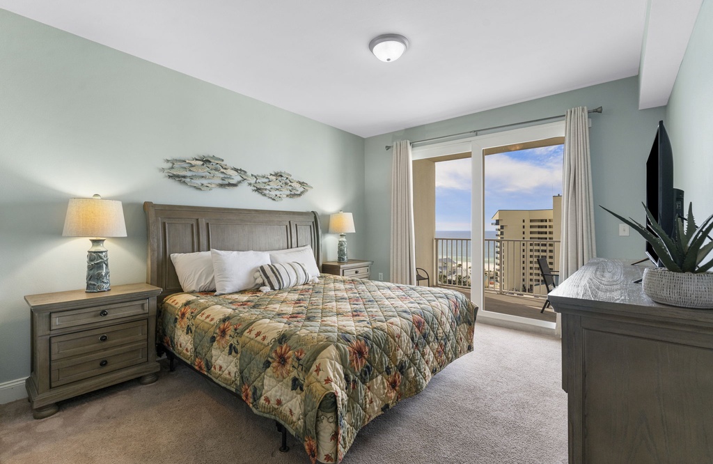 Relax in this coastal-inspired bedroom with balcony views of the city skyline.