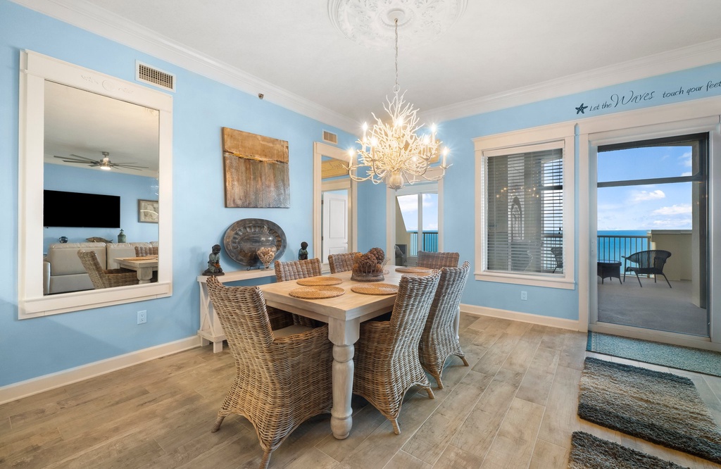 dining area with wicker chairs and ocean view balcony in a coastal-style setting