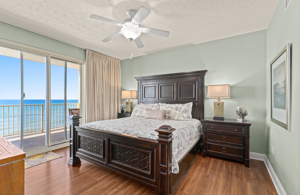Relax in this spacious bedroom with ocean views and classic wooden furnishings.