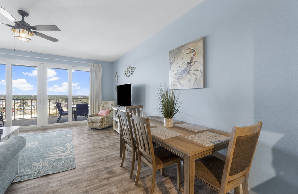 Dining area with natural light and balcony views in a coastal-style living space