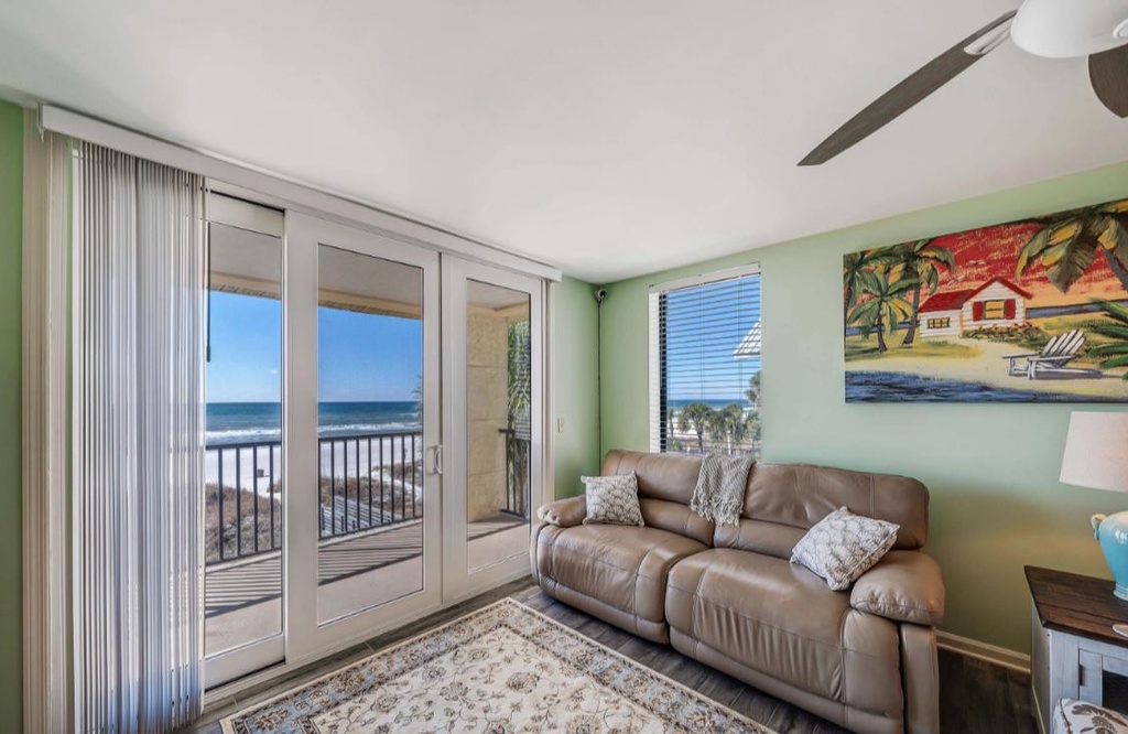 Relax in this bright living room where your private balcony opens to stunning ocean views and beach access.