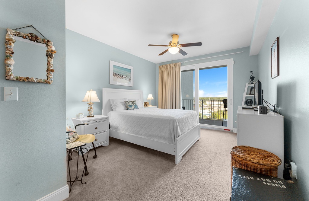 Relax in this bright bedroom with balcony access and coastal views.