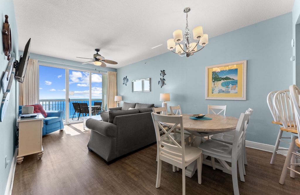 Open living & dining area w/ coastal charm, chandelier lighting, & sweeping ocean views.