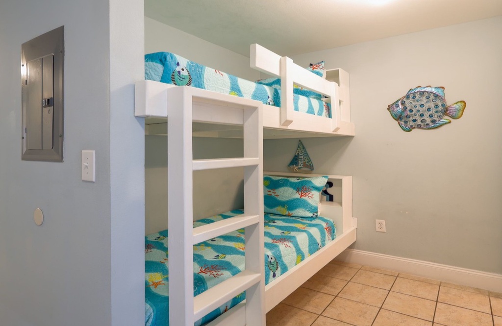 Cozy bunk room perfect for the kids, featuring bright ocean-themed bedding and playful decor to make their beach getaway extra special.
