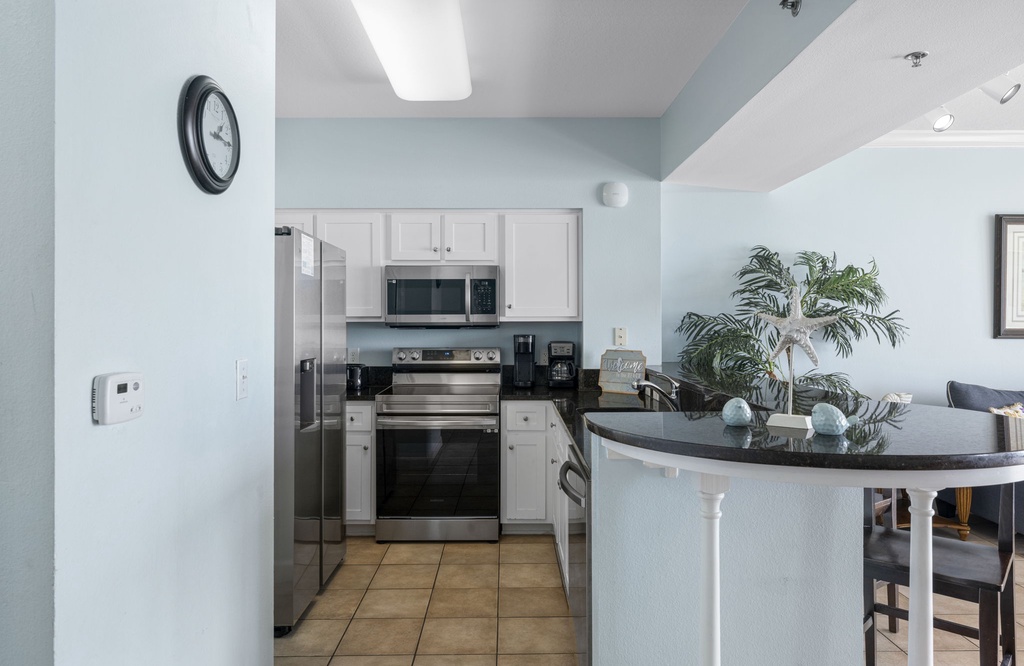 Modern kitchen with stainless steel appliances and a curved breakfast bar