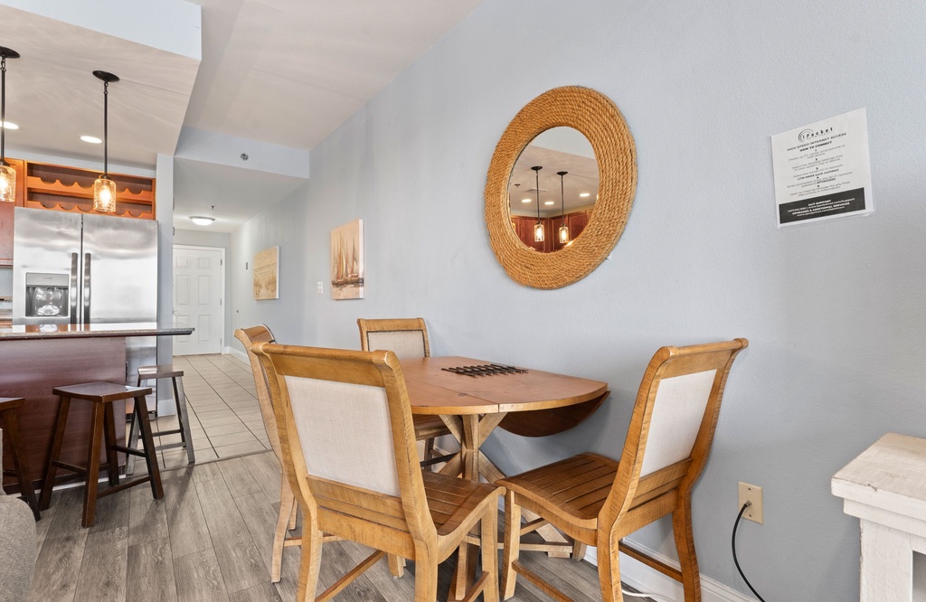 Cozy dining area with natural wood furniture and a round mirror.
