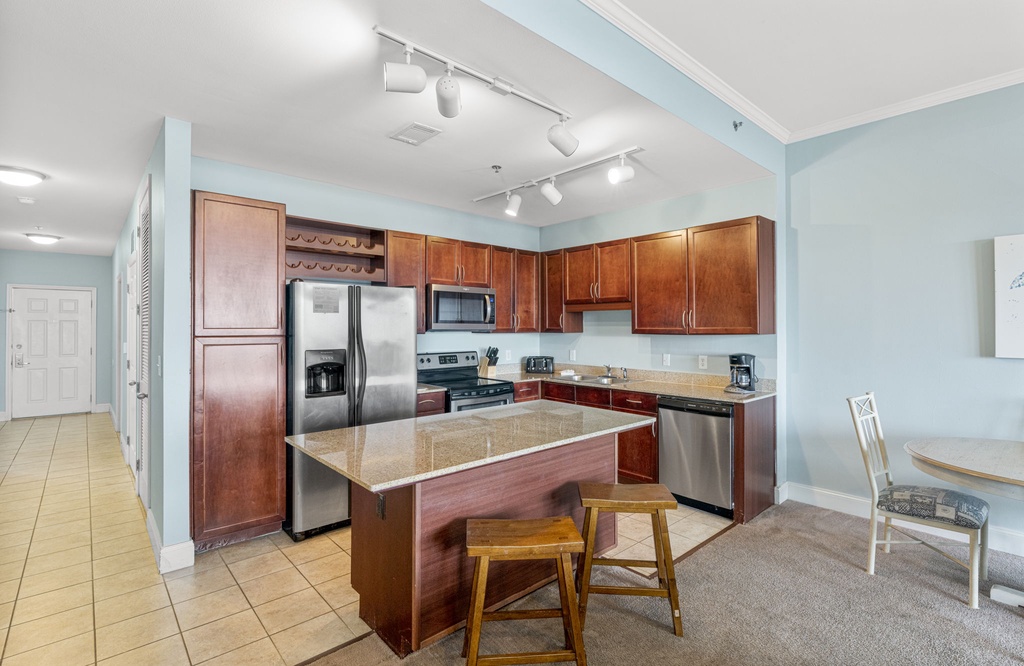 Modern kitchen with stainless steel appliances and a central island for casual dining.