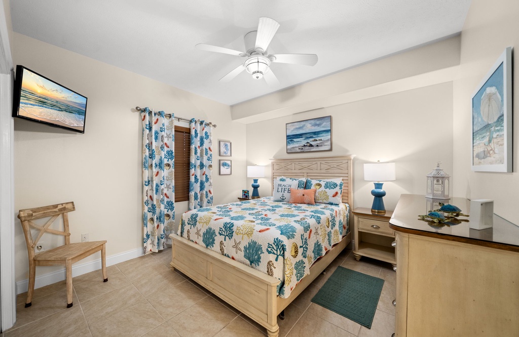 Cozy bedroom with coastal-themed decor and ceiling fan for a relaxing stay