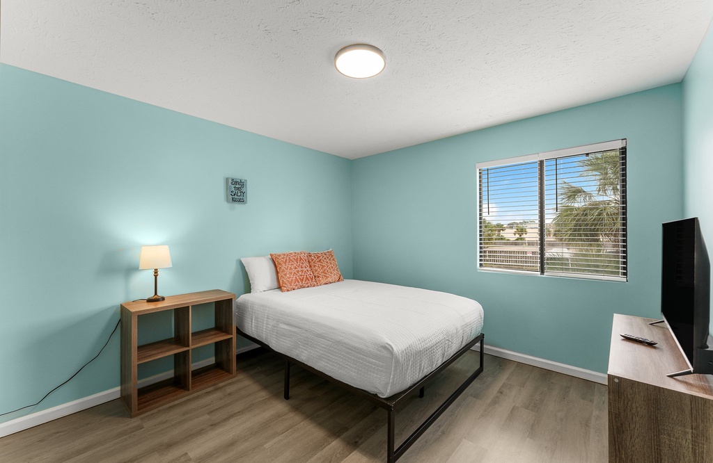Cozy bedroom with natural light and calming blue walls