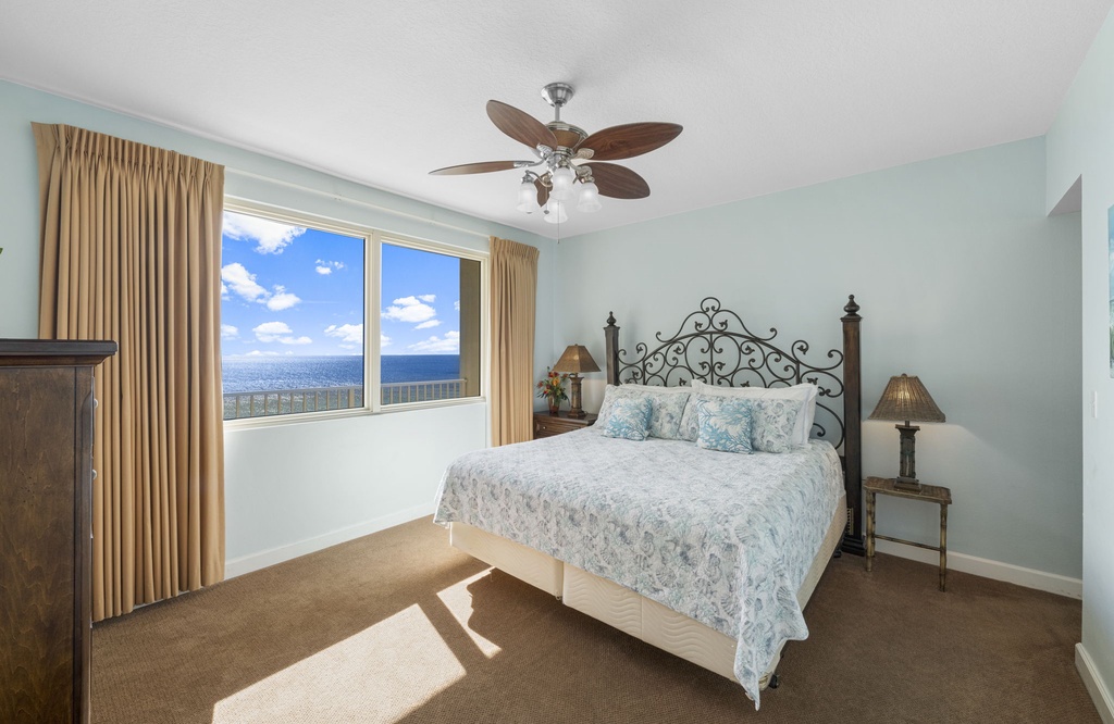 Relax in this bright bedroom with ocean views and classic decor.