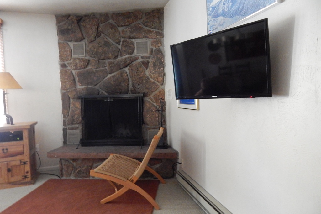 StayWinterPark Hideaway Village Columbine 7 TV and fireplace in living room