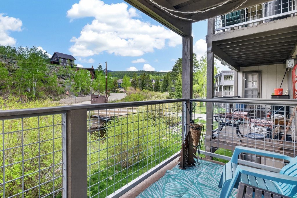 The property is nestled in a tranquil mountain setting, surrounded by lush greenery and distant hillsides, offering a peaceful retreat away from the bustle.