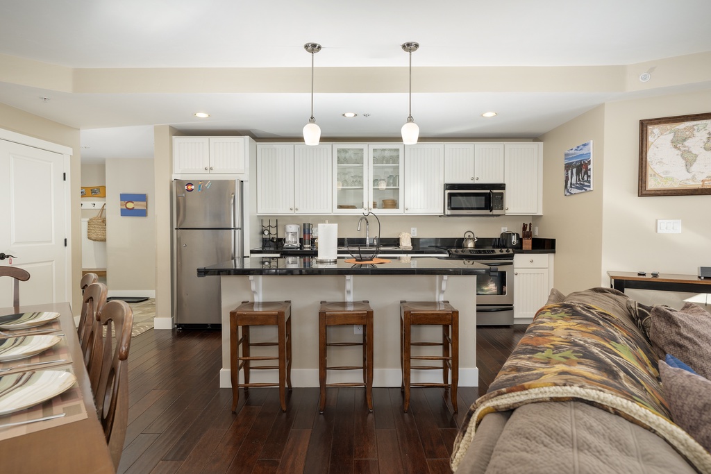 Relax in your open-concept living space where the fully equipped kitchen flows seamlessly into the comfortable living area, perfect for cooking and unwinding together.