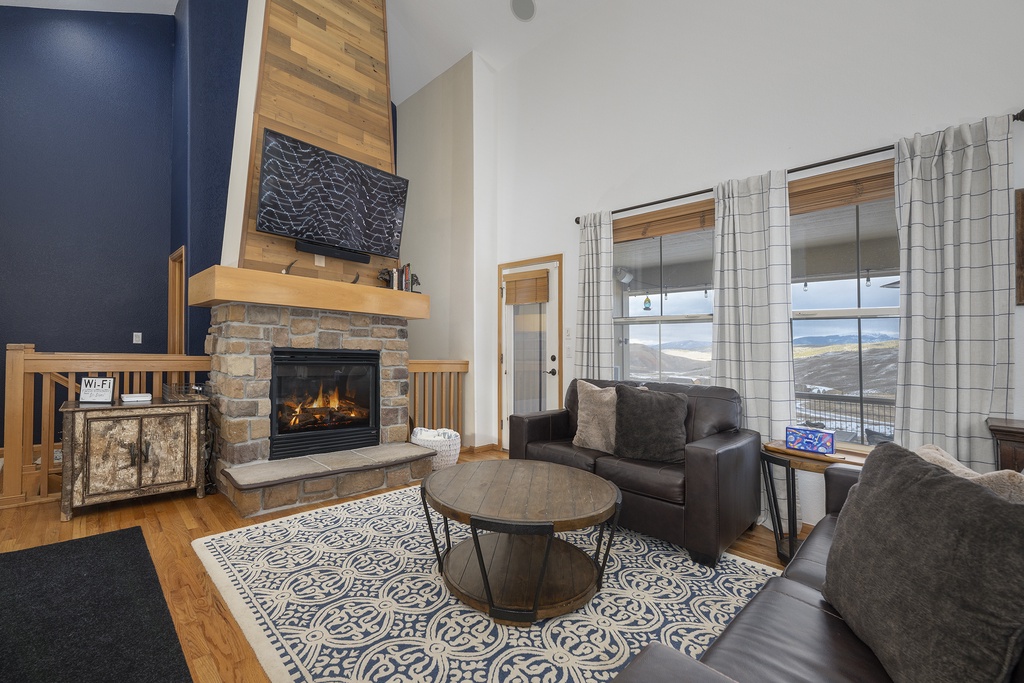 Settle into your cozy living room where a crackling fireplace warms the space while you admire mountain views through large windows.