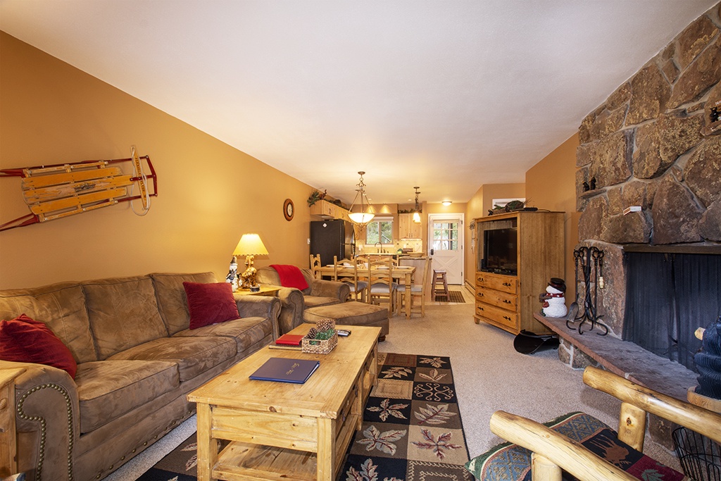 Cozy up by your stone fireplace in this warm living space, where plush seating and rustic charm create the perfect mountain retreat atmosphere.