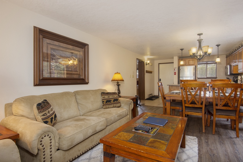 Sink into plush seating where warm mountain artwork and rustic wood create your perfect retreat after adventure-filled days.