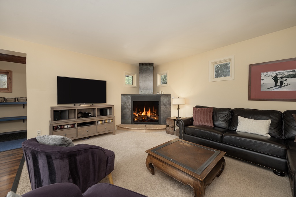 Sink into plush seating by your crackling fireplace, where cozy evenings unfold with your favorite shows on the large TV.