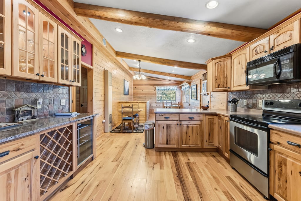 Your spacious kitchen invites home-cooked memories with rustic wood cabinetry, granite counters, and modern appliances.
