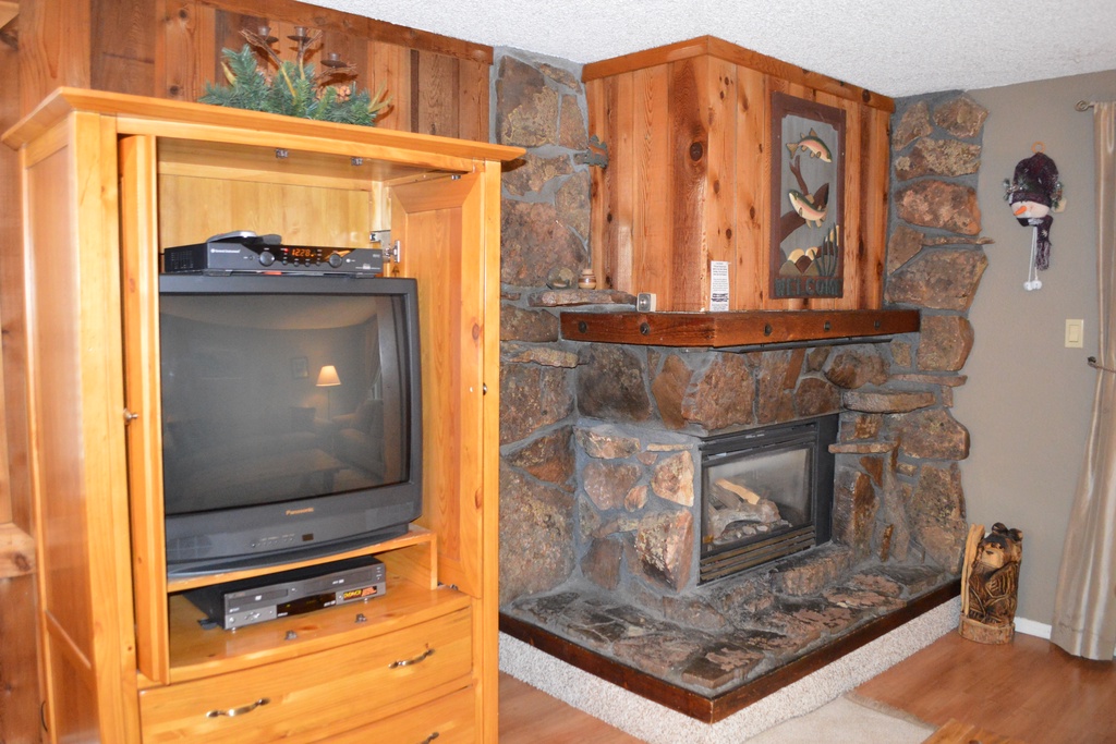 Cozy up by your stone fireplace while enjoying entertainment on the mounted TV in this warmly appointed cabin-style retreat.