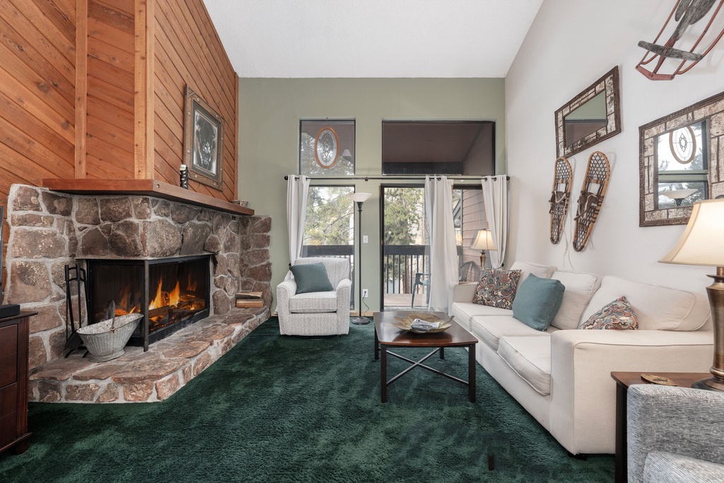 Curl up by your crackling stone fireplace in this cozy living room, complete with balcony access and mountain cabin charm.