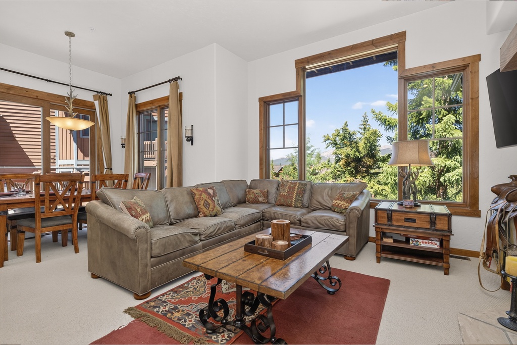 Unwind in your spacious living room with mountain views through large windows. Plush sectional seating and rustic wood accents create a warm, inviting atmosphere perfect for relaxing after your adventures.