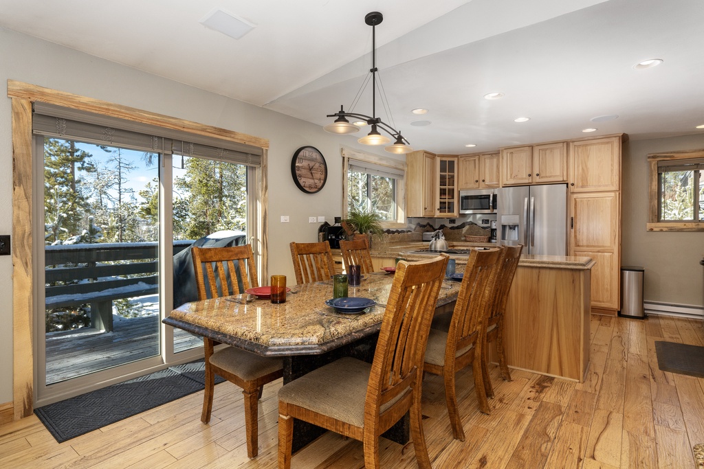 Gather around this elegant granite dining table where warm wood tones and mountain views create the perfect setting for your memorable meals together.