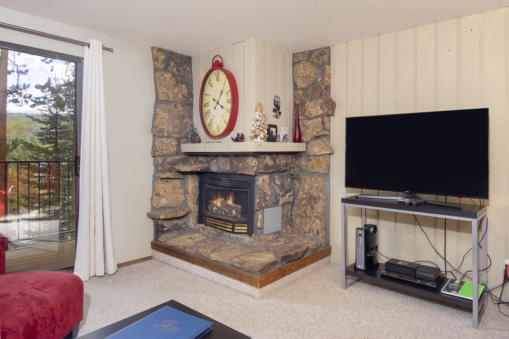 Cozy up by your stone fireplace while enjoying mountain views from the sliding door to your private balcony.