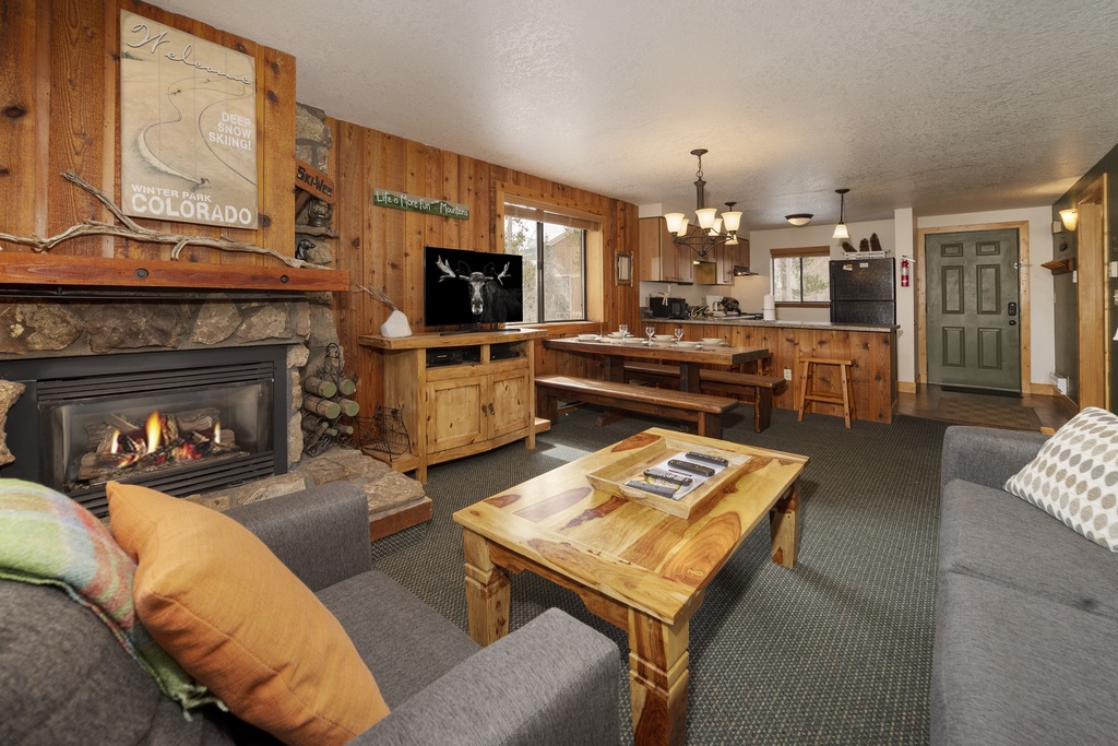 Cozy up by the crackling fireplace while enjoying mountain views from your rustic retreat's open living space.
