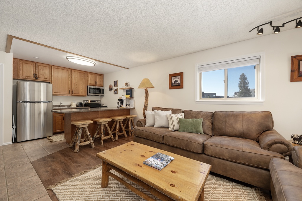 Sink into your comfortable leather sofa and enjoy this cozy open-plan space where rustic charm meets modern comfort in your mountain retreat.