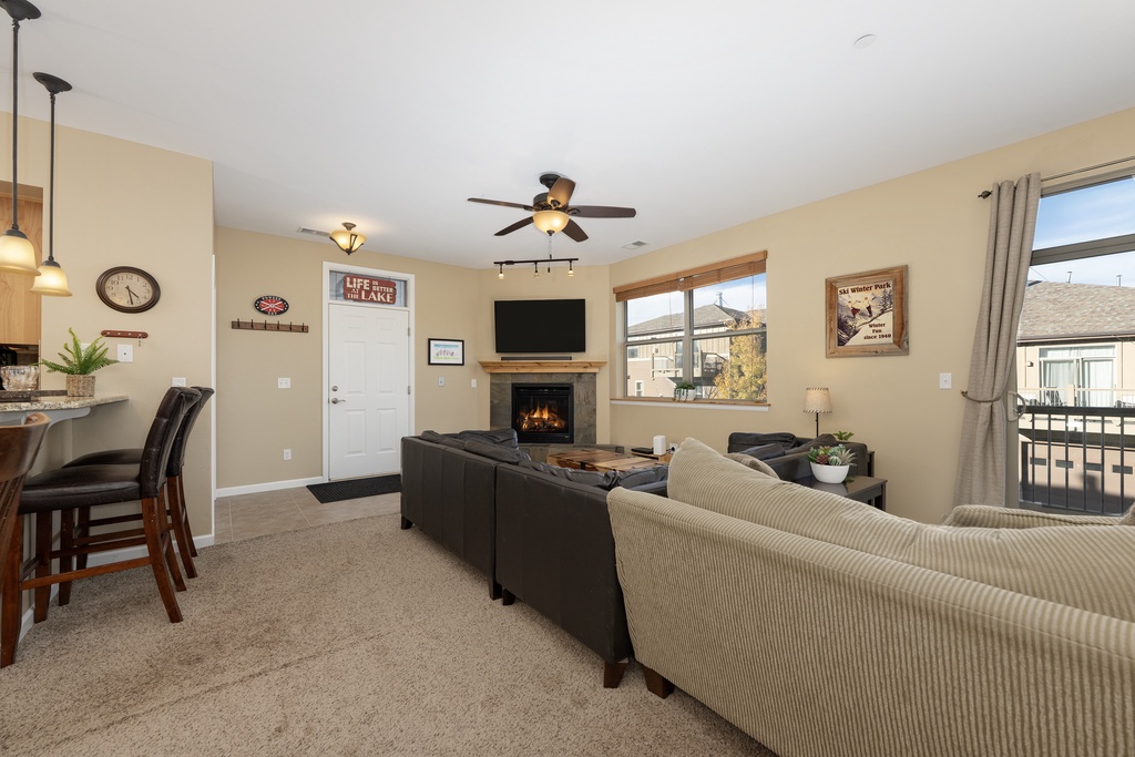Unwind in your open, inviting living room with cozy fireplace, modern ceiling fan, and plush seating where you can relax and make yourself at home.