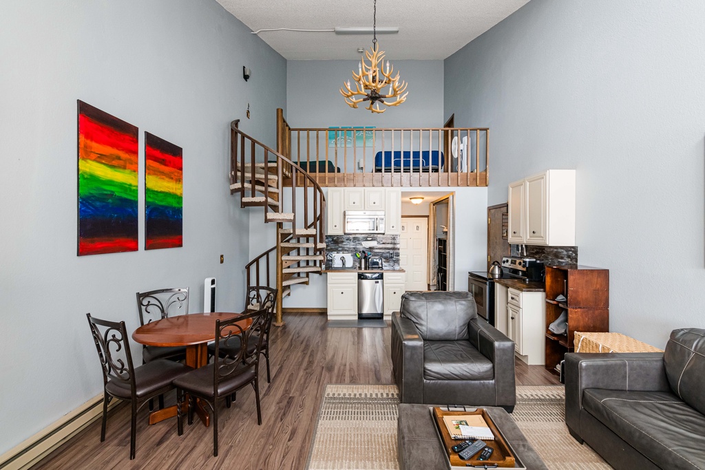 Your spacious loft at 643 SilverCreek Inn features soaring ceilings with a striking antler chandelier, leather seating, and a spiral staircase leading to your private upstairs retreat.
