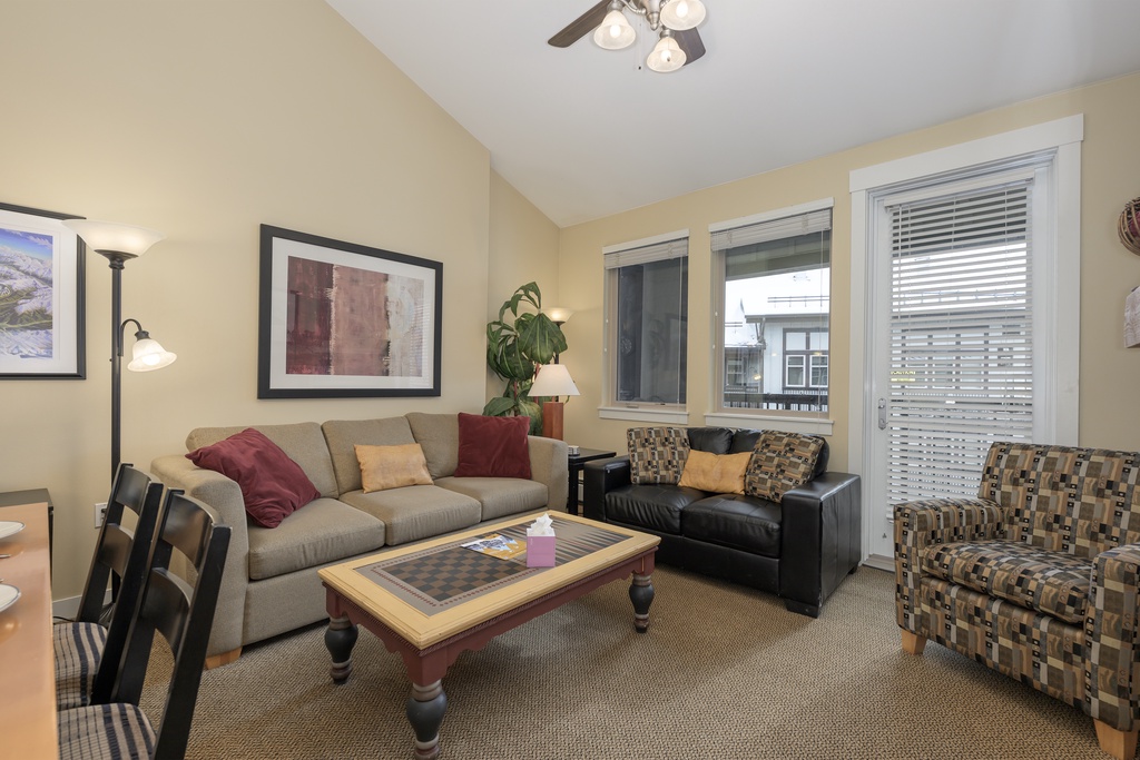 Relax in your comfortable living room featuring plush seating, warm lighting, and large windows that fill the space with natural light.