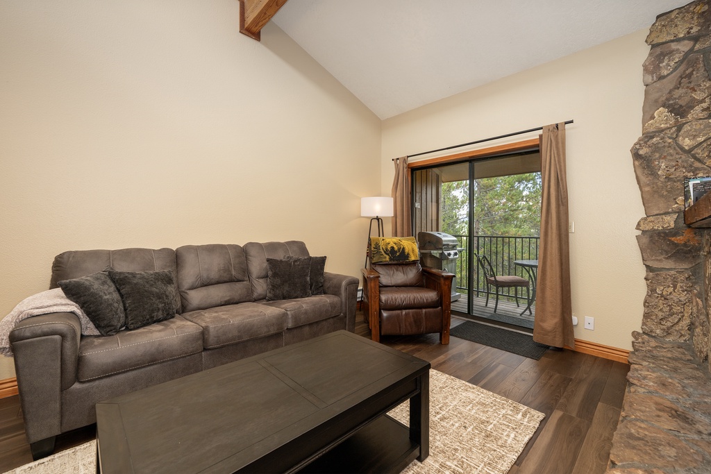 Unwind on the cozy sectional sofa with your morning coffee, enjoying peaceful tree views through the sliding glass doors to your private balcony.