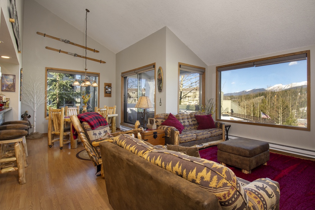 Relax in your cozy mountain retreat with rustic furnishings and stunning peak views through expansive windows.