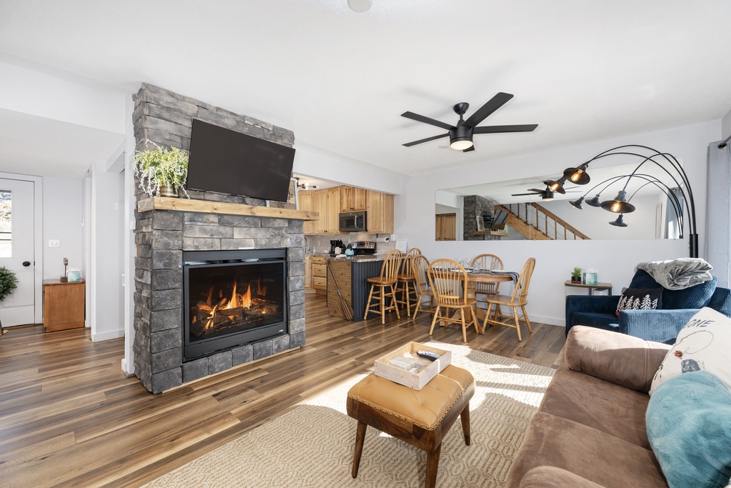 Cozy up by your stone fireplace while enjoying this open living space with modern kitchen and comfortable seating.