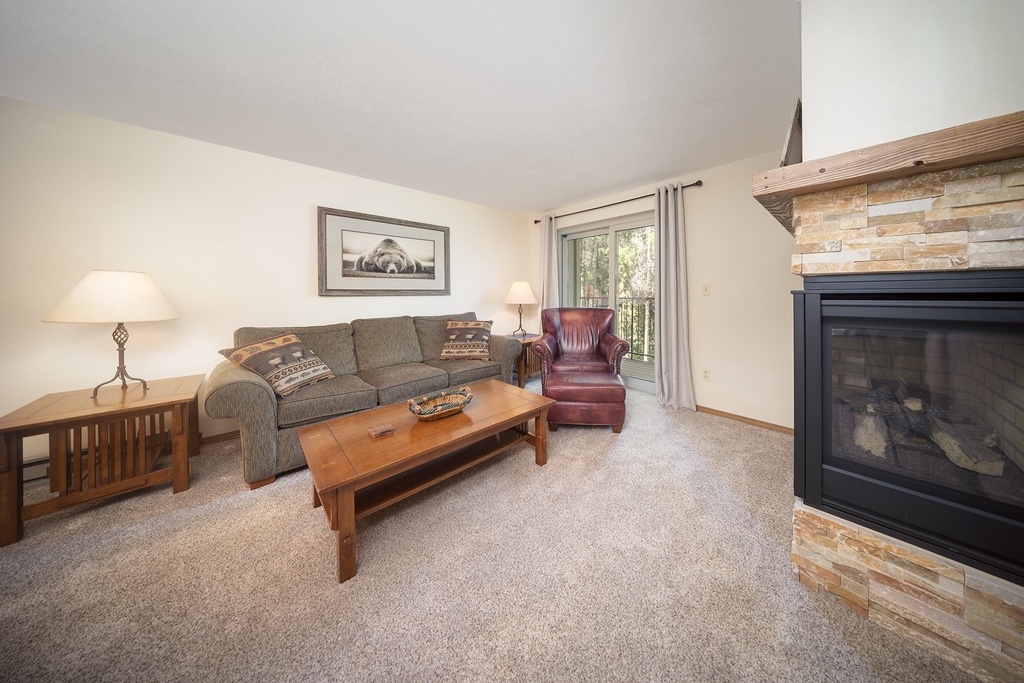 Unwind in your cozy living room with a crackling fireplace, plush seating, and warm mountain lodge charm.