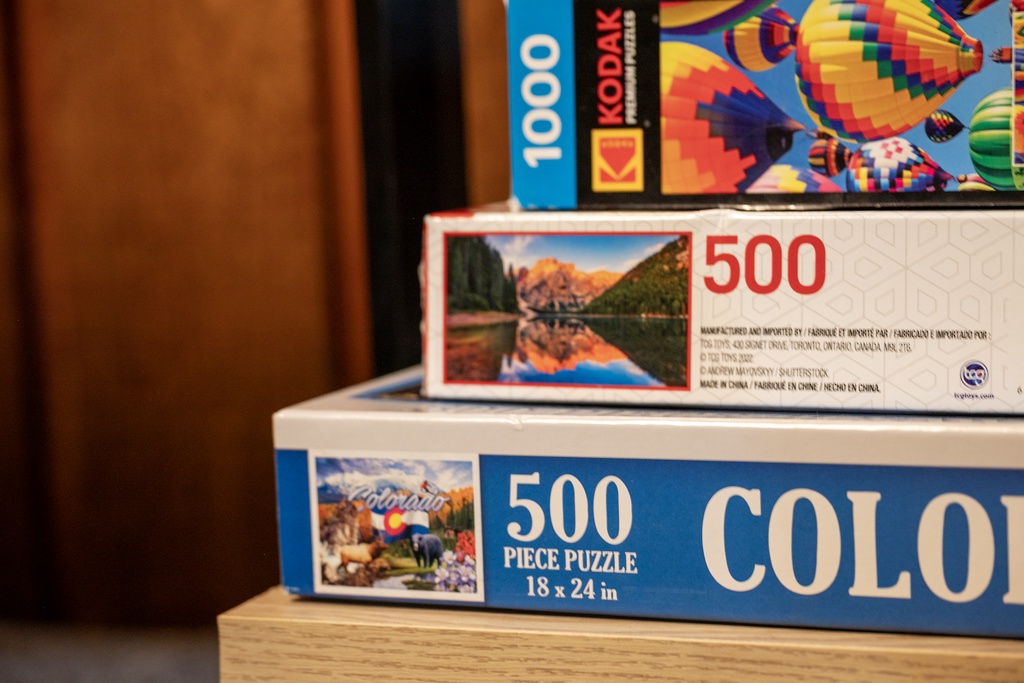Cozy up with puzzles for a perfect rainy day escape. Stack of games ready for your relaxing indoor adventure.