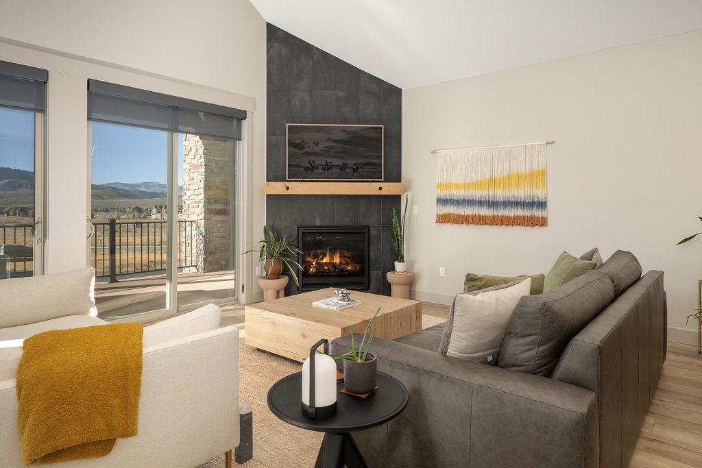 Unwind in your stylish living room with crackling fireplace, mountain views, and plush seating perfect for cozy evenings.