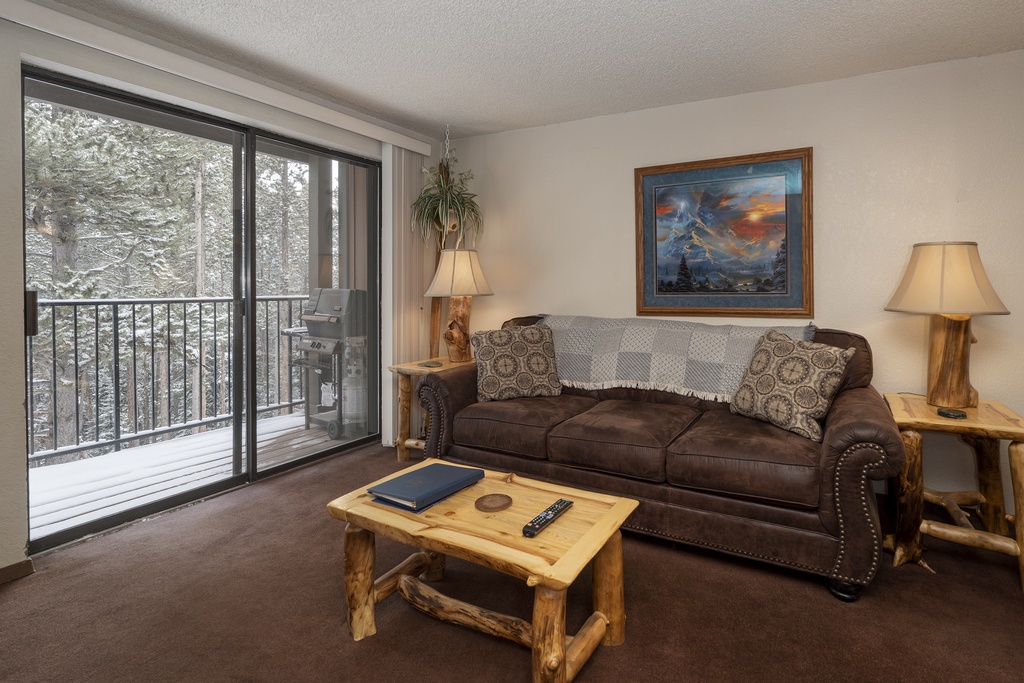 Cozy up on your leather sofa while admiring winter forest views through floor-to-ceiling windows on your private balcony.