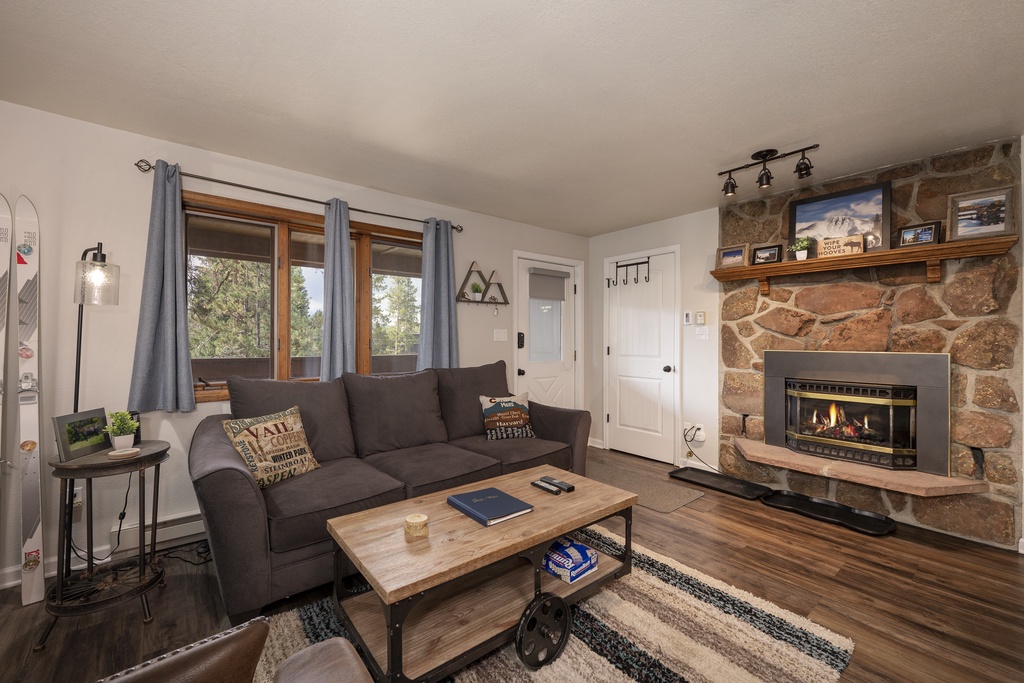 Unwind in your cozy living room with warm fireplace and mountain views through large windows.